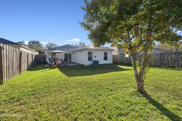 back of property with a yard, central AC unit, and a patio area