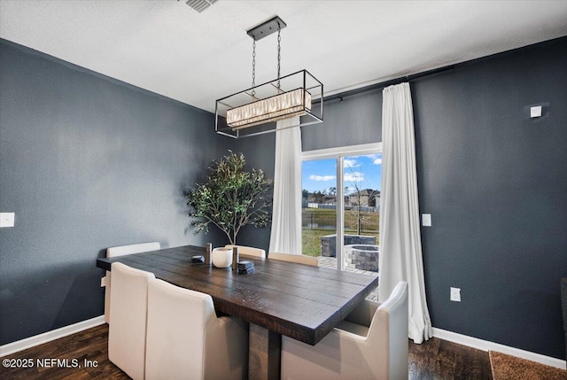 dining room with a chandelier and dark hardwood / wood-style floors