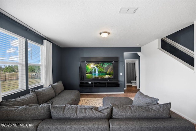 carpeted living room featuring a textured ceiling