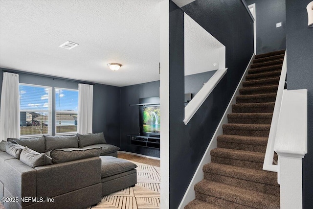 carpeted living room featuring a textured ceiling