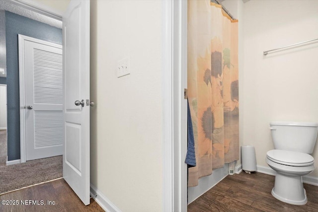 bathroom featuring wood-type flooring and toilet