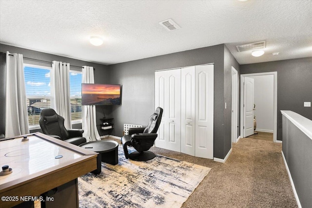 carpeted office featuring a textured ceiling