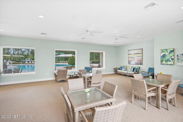 dining area with light carpet and ceiling fan