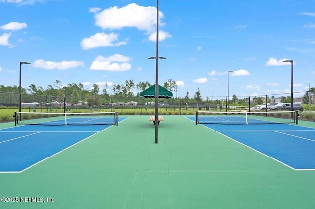 view of tennis court with basketball hoop