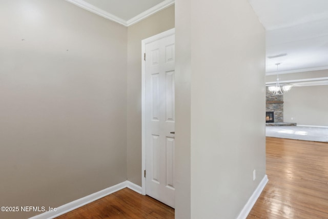 hallway featuring hardwood / wood-style flooring, a notable chandelier, and ornamental molding