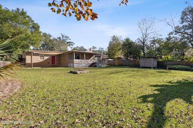 view of yard with a fire pit and a storage shed