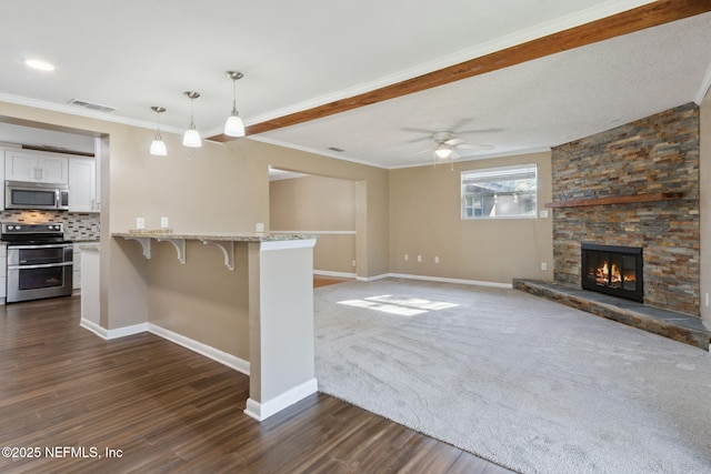 kitchen with ceiling fan, stainless steel appliances, pendant lighting, a kitchen bar, and white cabinets