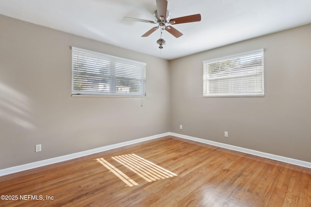 empty room with a wealth of natural light, ceiling fan, and light hardwood / wood-style floors