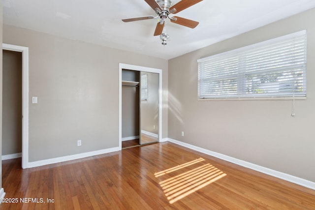 unfurnished bedroom featuring ceiling fan, wood-type flooring, and a closet