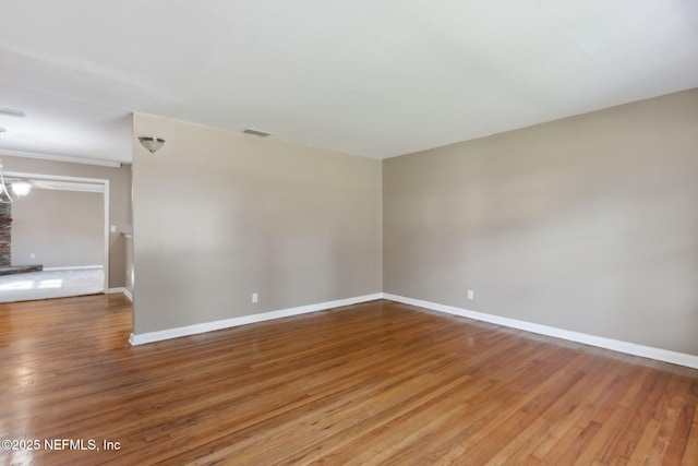 empty room with wood-type flooring and a fireplace