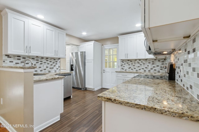 kitchen featuring light stone countertops, tasteful backsplash, stainless steel appliances, sink, and white cabinets