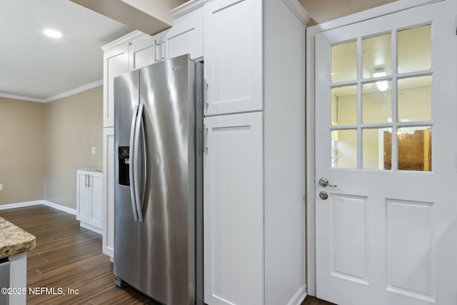 kitchen with white cabinetry, dark wood-type flooring, light stone counters, stainless steel refrigerator with ice dispenser, and ornamental molding