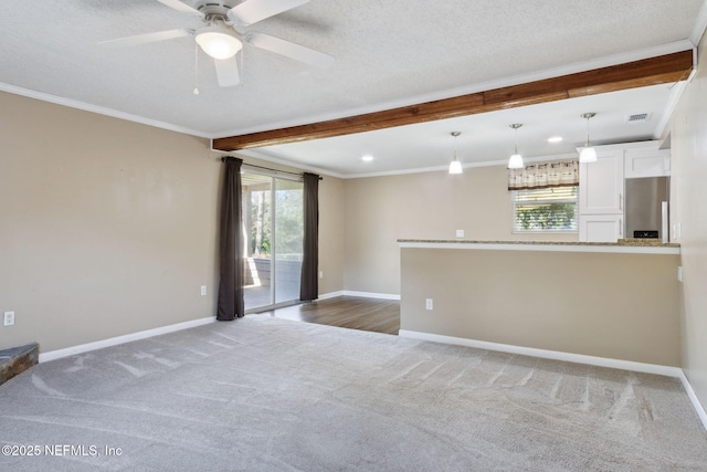 carpeted empty room with plenty of natural light, ceiling fan, ornamental molding, and a textured ceiling