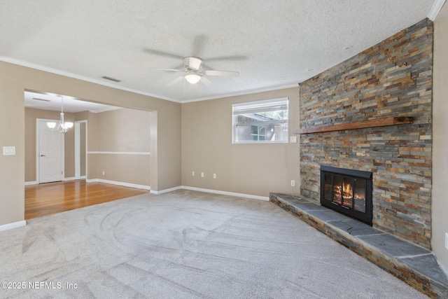 unfurnished living room with carpet floors, a textured ceiling, a fireplace, ceiling fan with notable chandelier, and ornamental molding