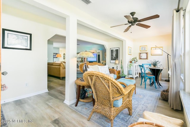 living room featuring ceiling fan and light hardwood / wood-style flooring