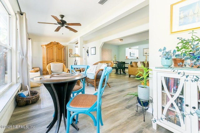 dining space with ceiling fan and light hardwood / wood-style flooring