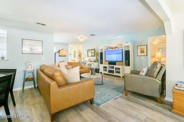 living room with light hardwood / wood-style flooring and ceiling fan