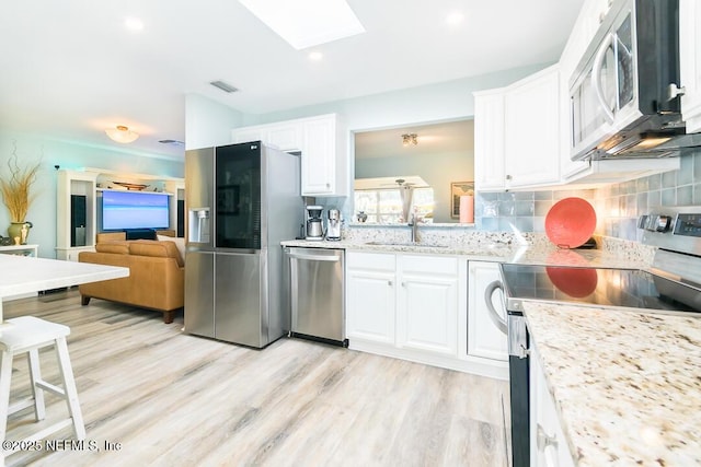 kitchen featuring white cabinets, light stone counters, sink, and stainless steel appliances