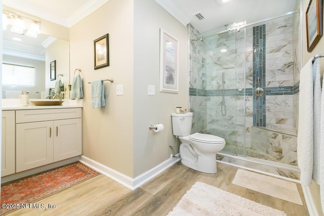 bathroom featuring wood-type flooring, vanity, crown molding, and a shower with shower door