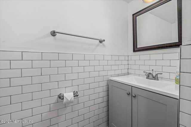 bathroom featuring vanity and tile walls