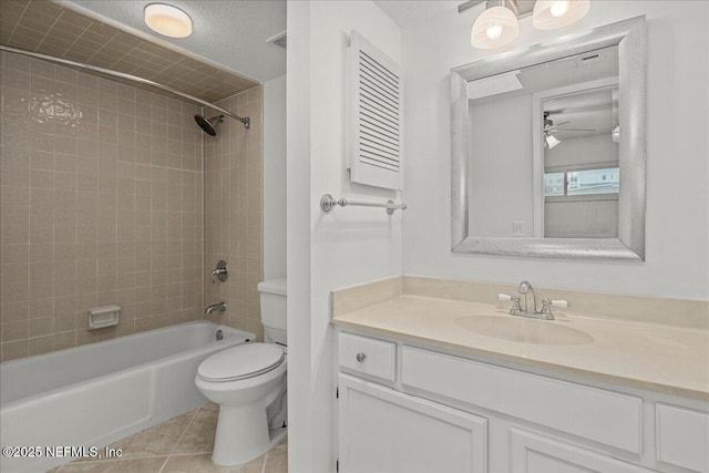 full bathroom with tile patterned floors, a textured ceiling, toilet, vanity, and tiled shower / bath