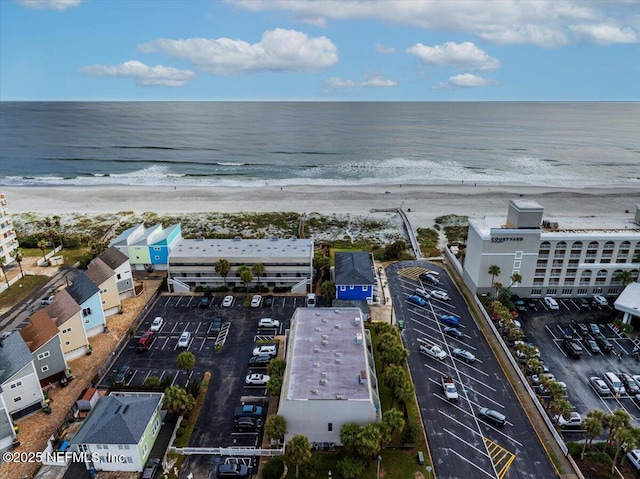 birds eye view of property featuring a water view and a beach view