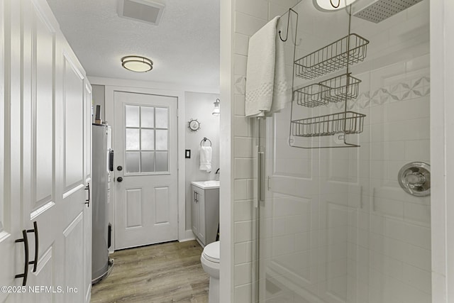 bathroom with electric water heater, an enclosed shower, toilet, and hardwood / wood-style flooring