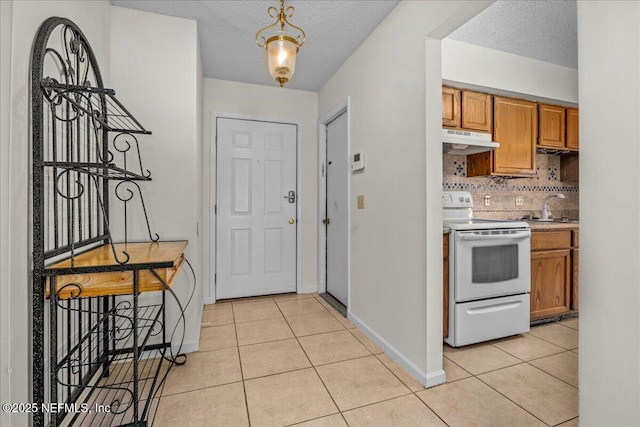 tiled entrance foyer featuring a textured ceiling and sink