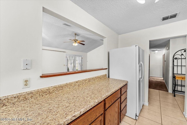 kitchen featuring ceiling fan, light tile patterned flooring, white refrigerator with ice dispenser, and a textured ceiling