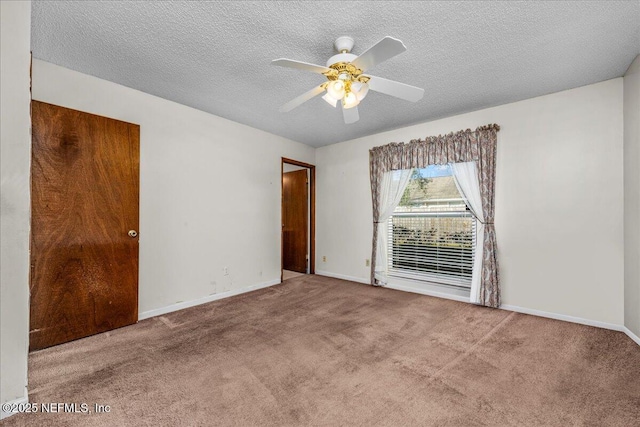 carpeted empty room featuring ceiling fan and a textured ceiling