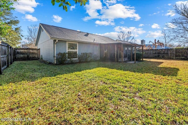 back of house with a yard and a sunroom