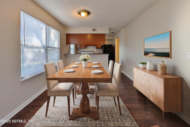 dining area with a wealth of natural light and dark wood-type flooring