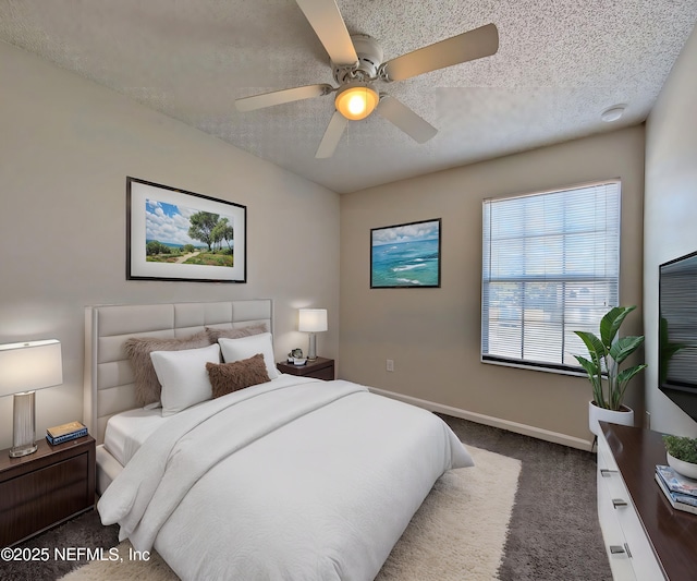 bedroom with dark colored carpet, ceiling fan, and a textured ceiling