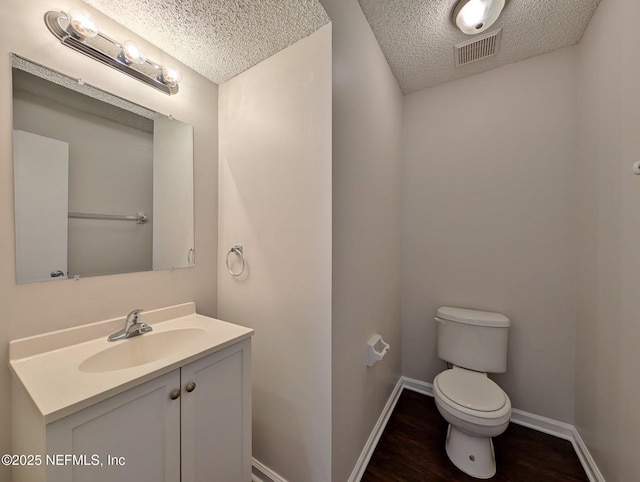 bathroom with vanity, hardwood / wood-style floors, a textured ceiling, and toilet