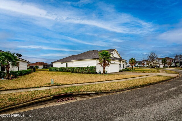 95220 Snapdragon Dr, Fernandina Beach, FL 32034 - view of property exterior with a yard, a residential view, concrete driveway, and an attached garage