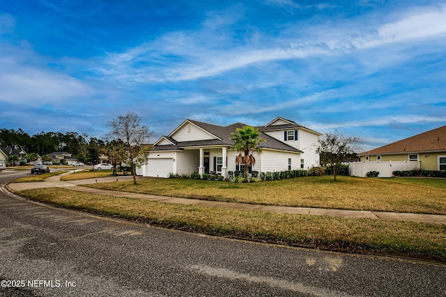95220 Snapdragon Dr, Fernandina Beach, FL 32034 - traditional-style home with a front lawn, driveway, a garage, and fence