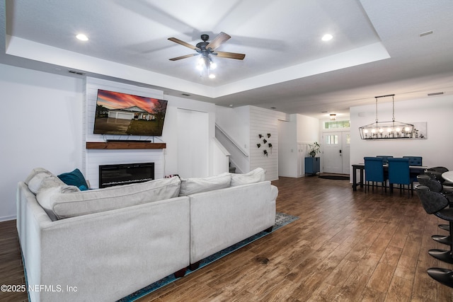 95220 Snapdragon Dr, Fernandina Beach, FL 32034 - living area featuring dark wood finished floors, stairs, ceiling fan, a fireplace, and a tray ceiling