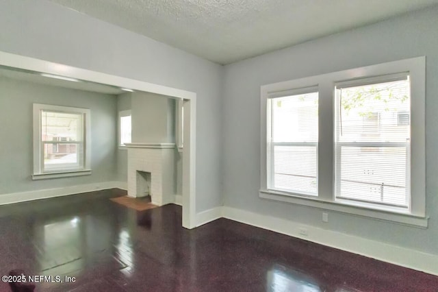 unfurnished living room featuring a fireplace and a textured ceiling