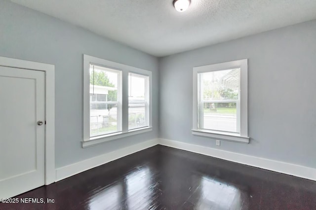 unfurnished room featuring hardwood / wood-style flooring and a wealth of natural light