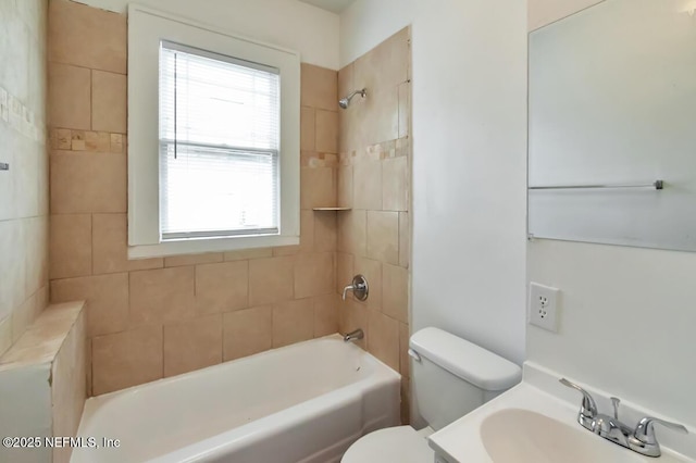 full bathroom with vanity, tiled shower / bath combo, toilet, and a healthy amount of sunlight