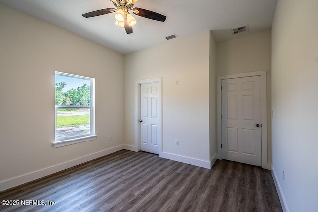 unfurnished bedroom featuring dark hardwood / wood-style flooring and ceiling fan