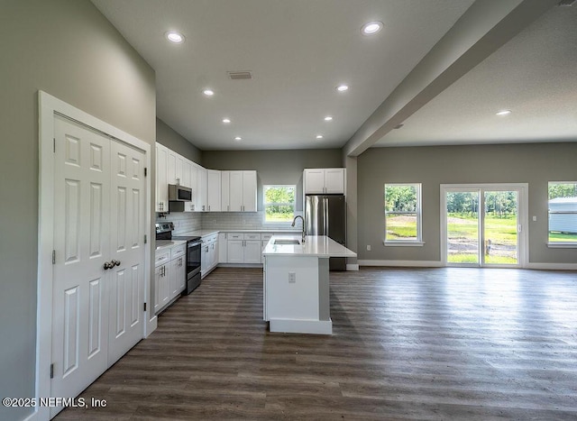 kitchen with a wealth of natural light, white cabinetry, a center island with sink, and stainless steel appliances