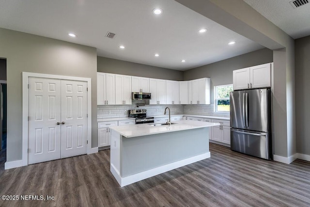 kitchen with a kitchen island with sink, white cabinetry, sink, and appliances with stainless steel finishes