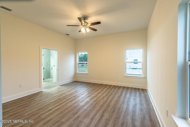 spare room with ceiling fan and dark wood-type flooring