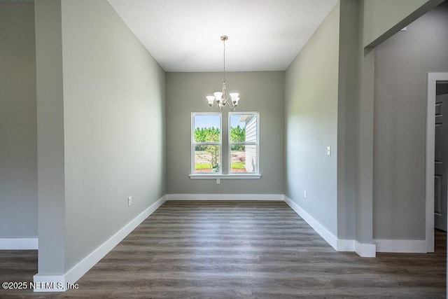 unfurnished dining area with dark hardwood / wood-style flooring and a chandelier