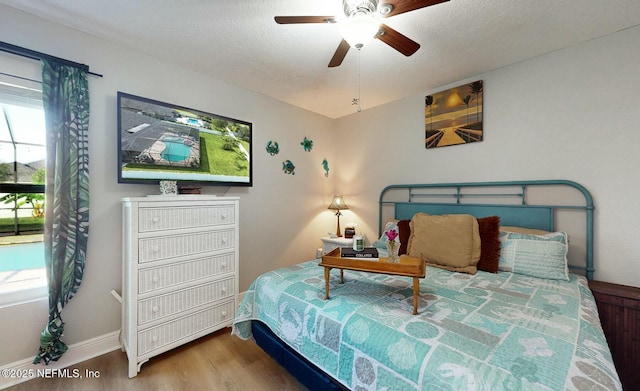 bedroom with hardwood / wood-style floors, a textured ceiling, and ceiling fan