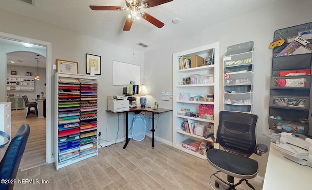 office with a textured ceiling, light hardwood / wood-style floors, and ceiling fan