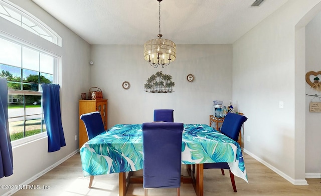 dining space featuring a chandelier, light hardwood / wood-style flooring, and a wealth of natural light