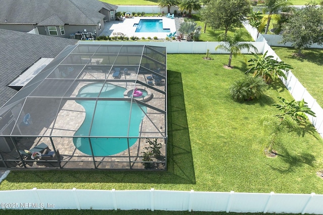 view of swimming pool featuring a yard, glass enclosure, and a patio area