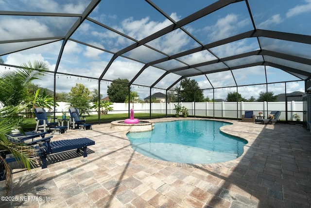 view of swimming pool featuring glass enclosure and a patio